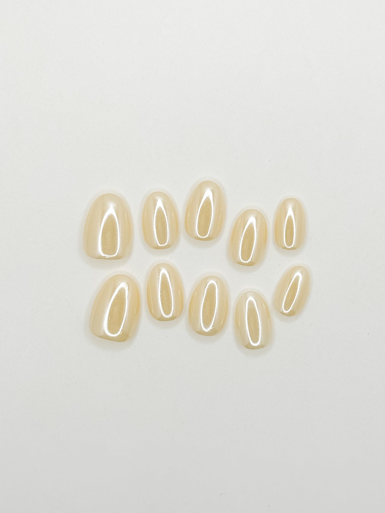 Butter yellow glazed press-on nails in an extra short oval shape with a glossy creamy finish. Handmade reusable false nails inspired by butter yellow nails, soft pastel manicures and clean girl summer nail trends.