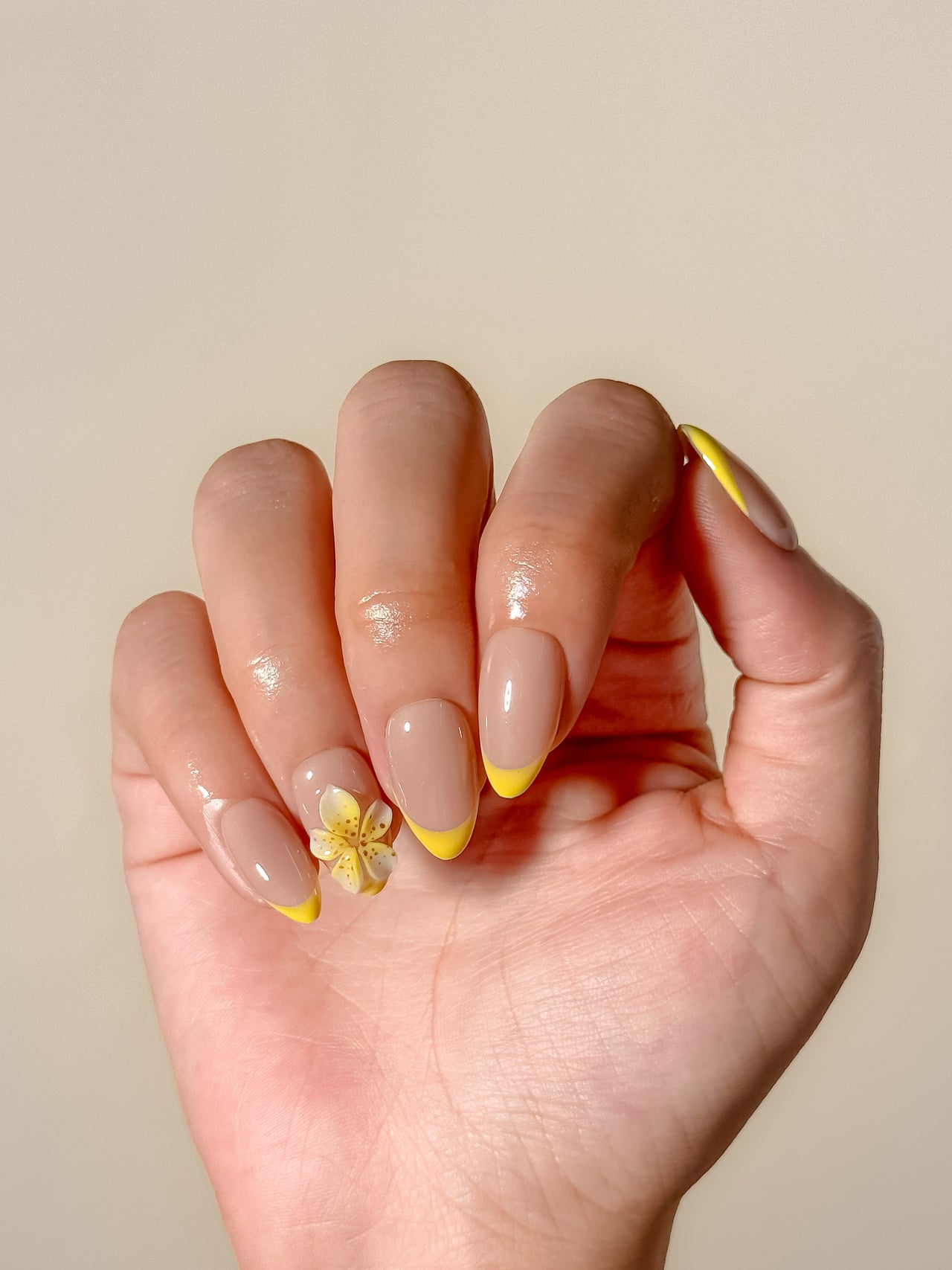 Fresh lemon-yellow French tip press-on nails with a glossy finish, featuring a soft almond shape and a clean citrus-inspired design for a playful yet elevated look.