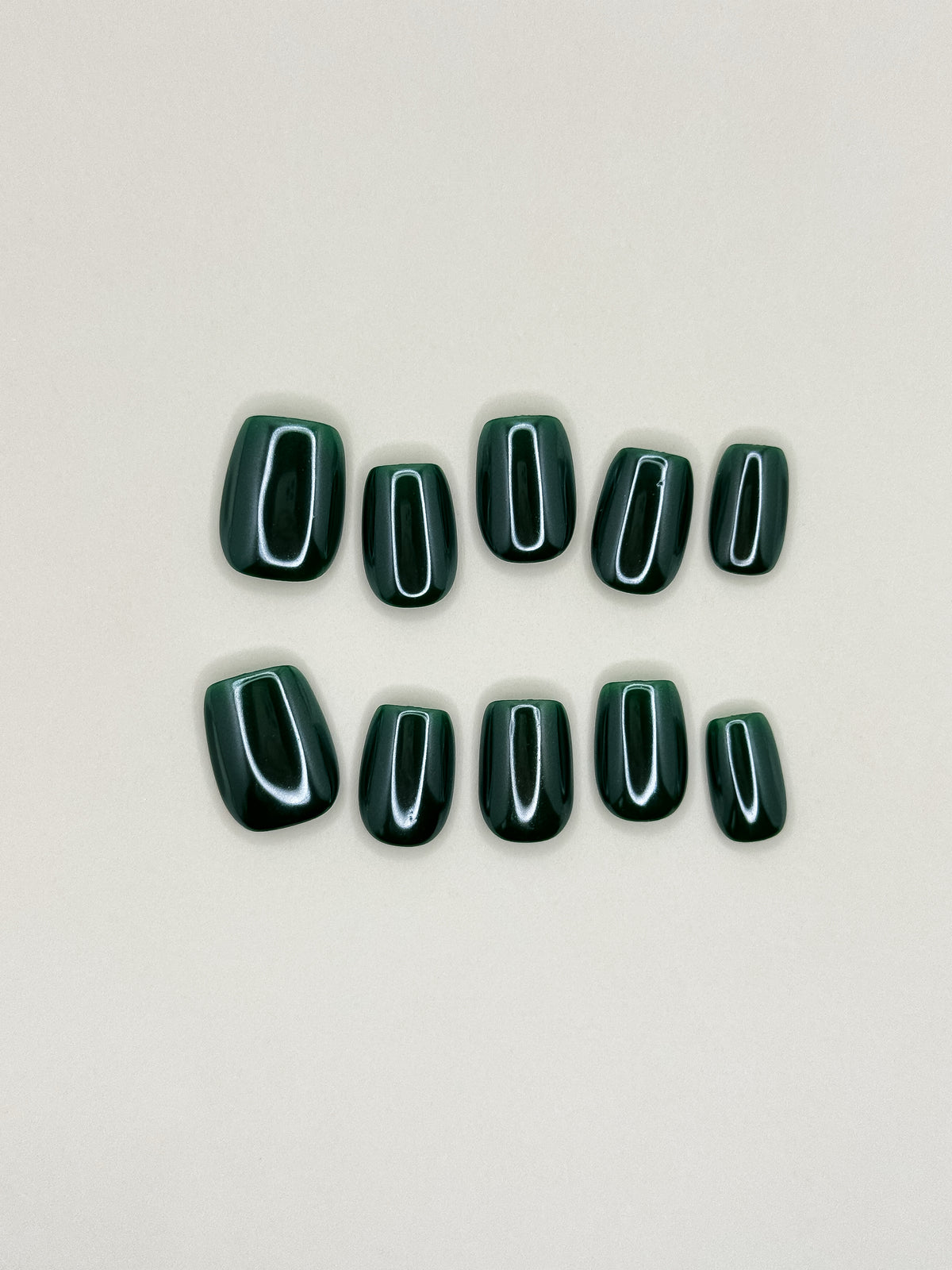 Promotion deep forest green short square press-on nails arranged as a glossy reusable set on a white background.