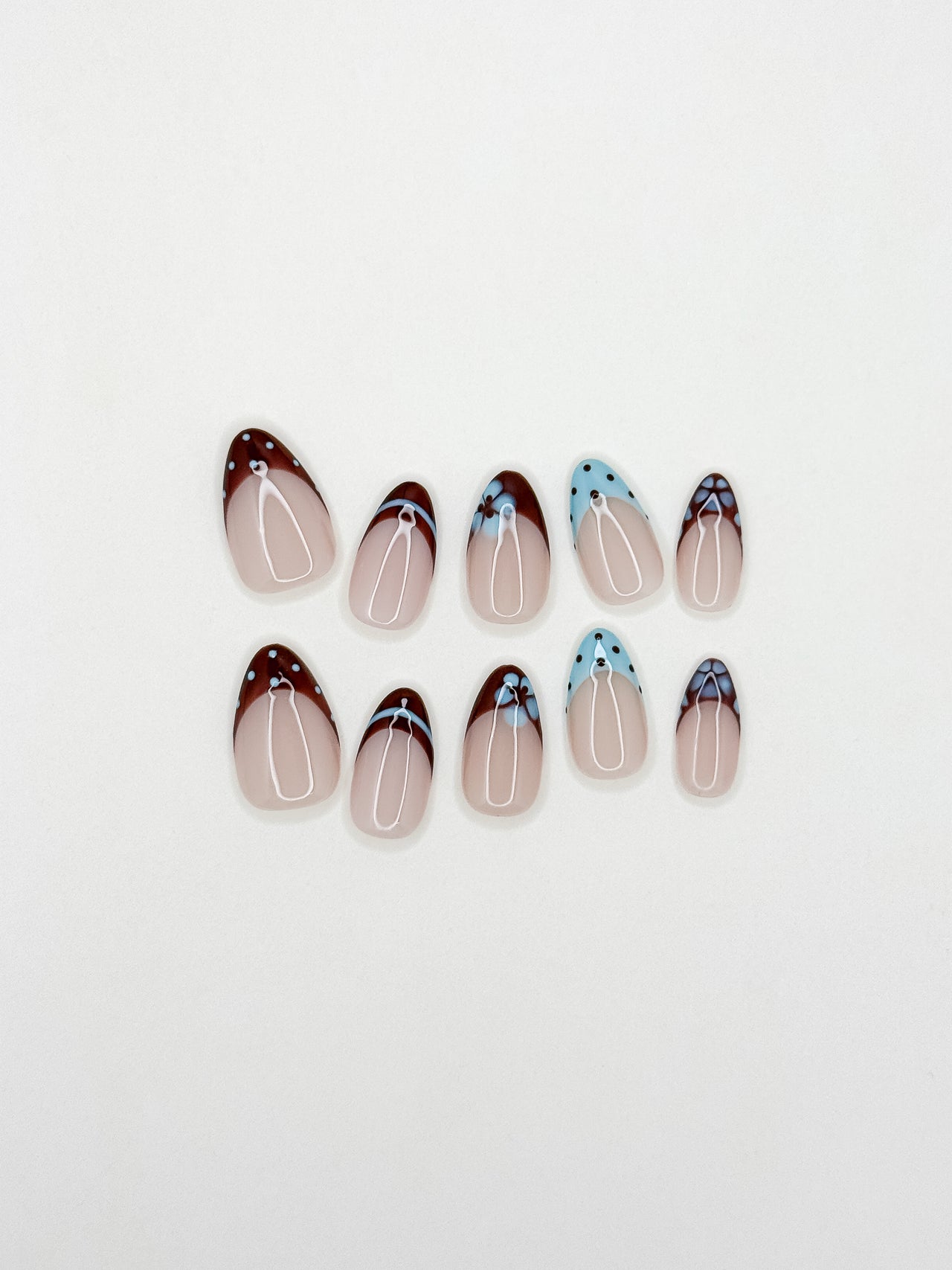 Brown and baby blue French tip press-on nails with retro floral detailing in a short almond shape. Handmade reusable false nails inspired by vintage 70s nail art, soft mod colour palettes and playful minimalist French manicure styles.