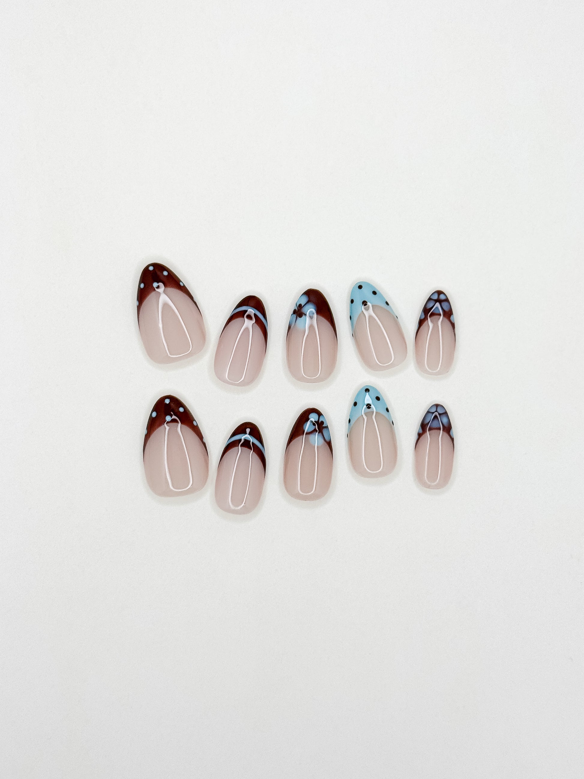 Brown and baby blue French tip press-on nails with retro floral detailing in a short almond shape. Handmade reusable false nails inspired by vintage 70s nail art, soft mod colour palettes and playful minimalist French manicure styles.