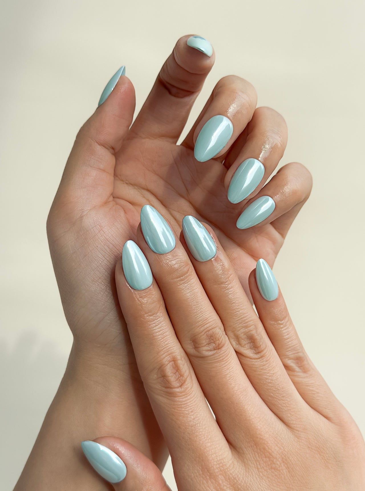 Bluebell Glaze handmade reusable press-on nails laid flat, featuring a soft powder-blue colour, pearly glazed finish and glossy medium almond shape.