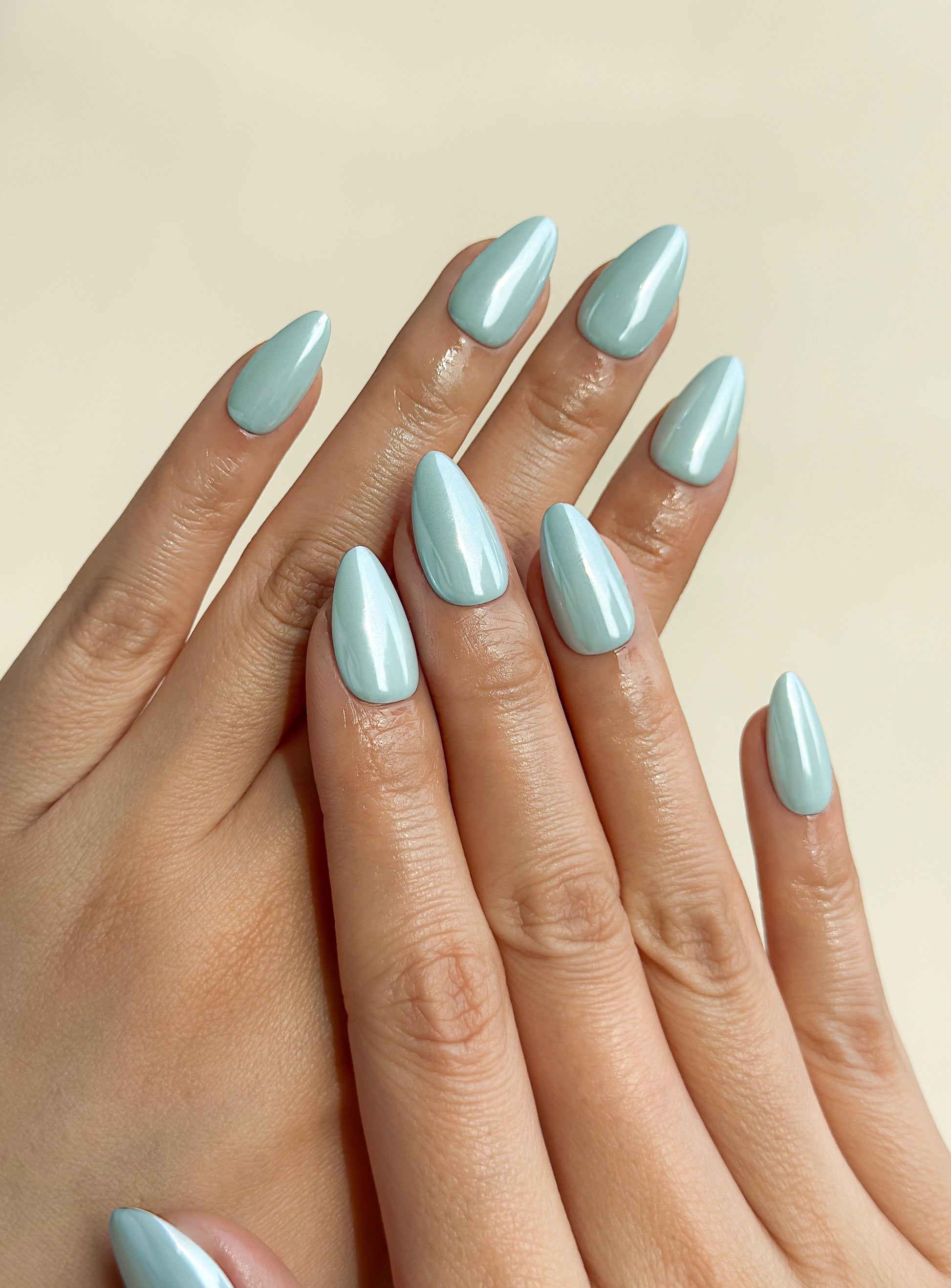 Bluebell Glaze handmade press-on nails on hands, featuring a powder-blue pearly glazed finish with a soft light-catching shine.