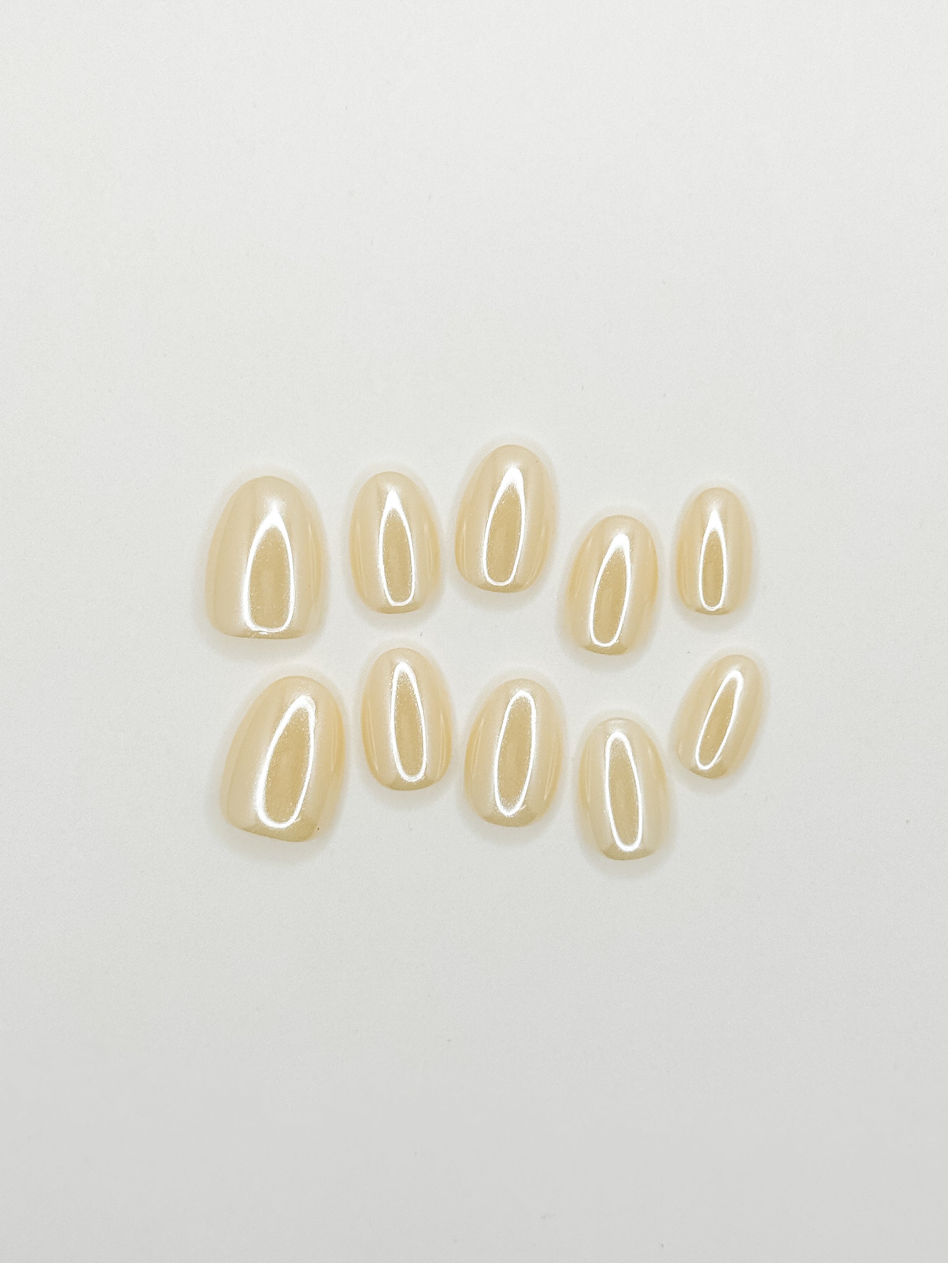 Butter yellow glazed press-on nails in an extra short oval shape with a glossy creamy finish. Handmade reusable false nails inspired by butter yellow nails, soft pastel manicures and clean girl summer nail trends.
