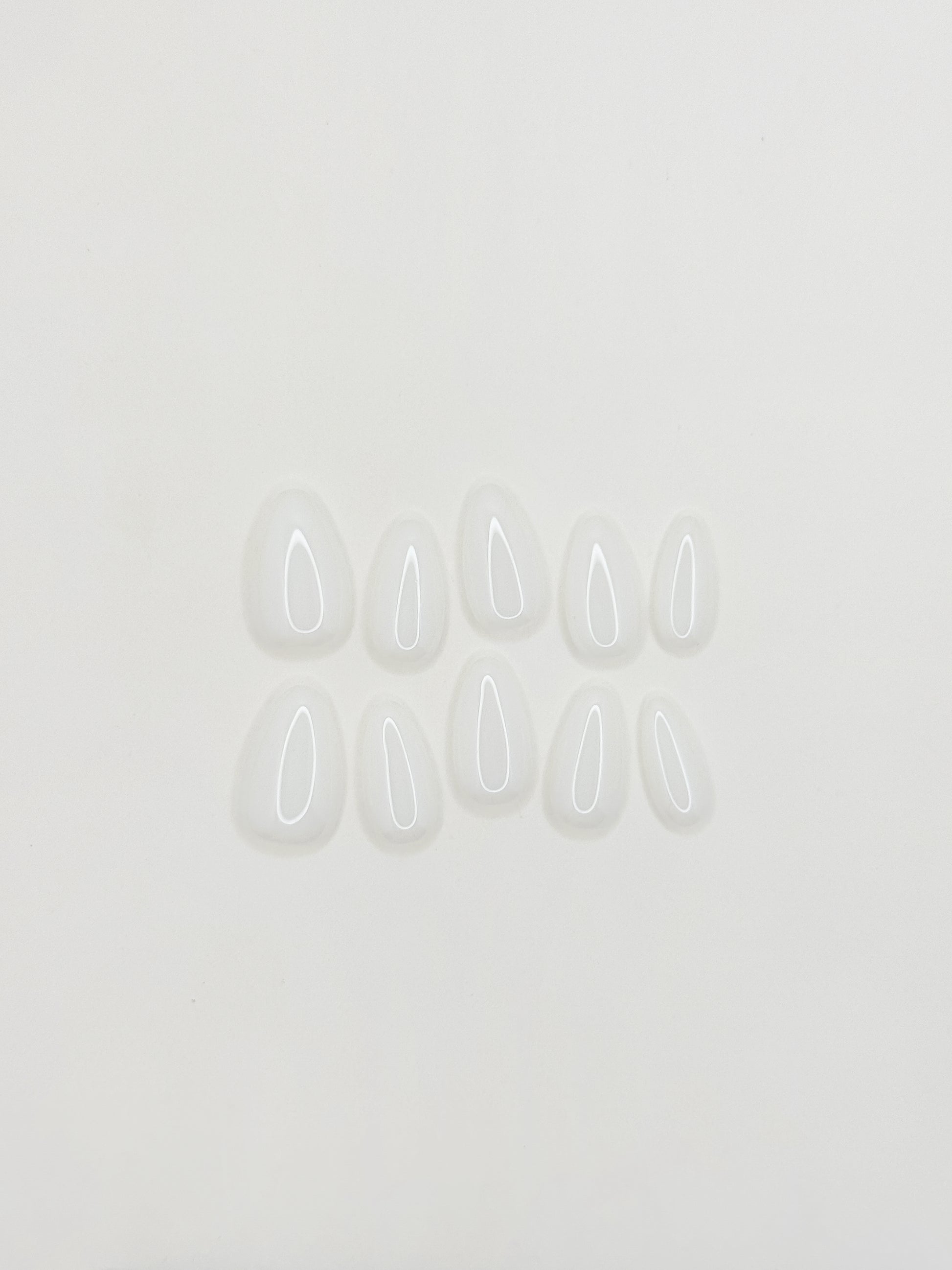 Glossy creamy ivory press-on nails in a short almond shape with a smooth gel-like milky finish. Handmade reusable false nails inspired by vanilla cream nails, clean girl manicures and minimalist neutral nail trends.