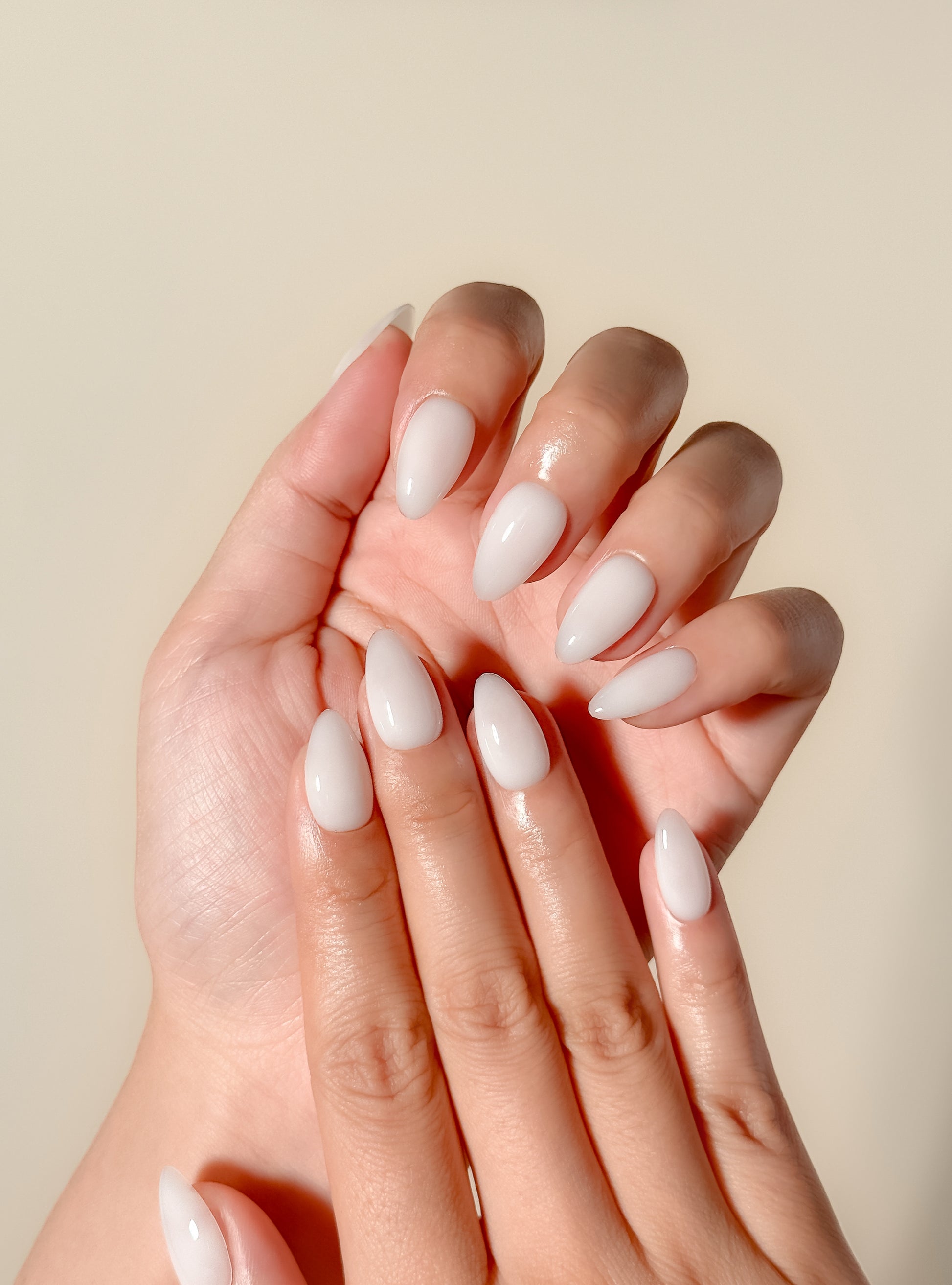 Glossy creamy ivory press-on nails in a short almond shape with a smooth gel-like milky finish. Handmade reusable false nails inspired by vanilla cream nails, clean girl manicures and minimalist neutral nail trends.