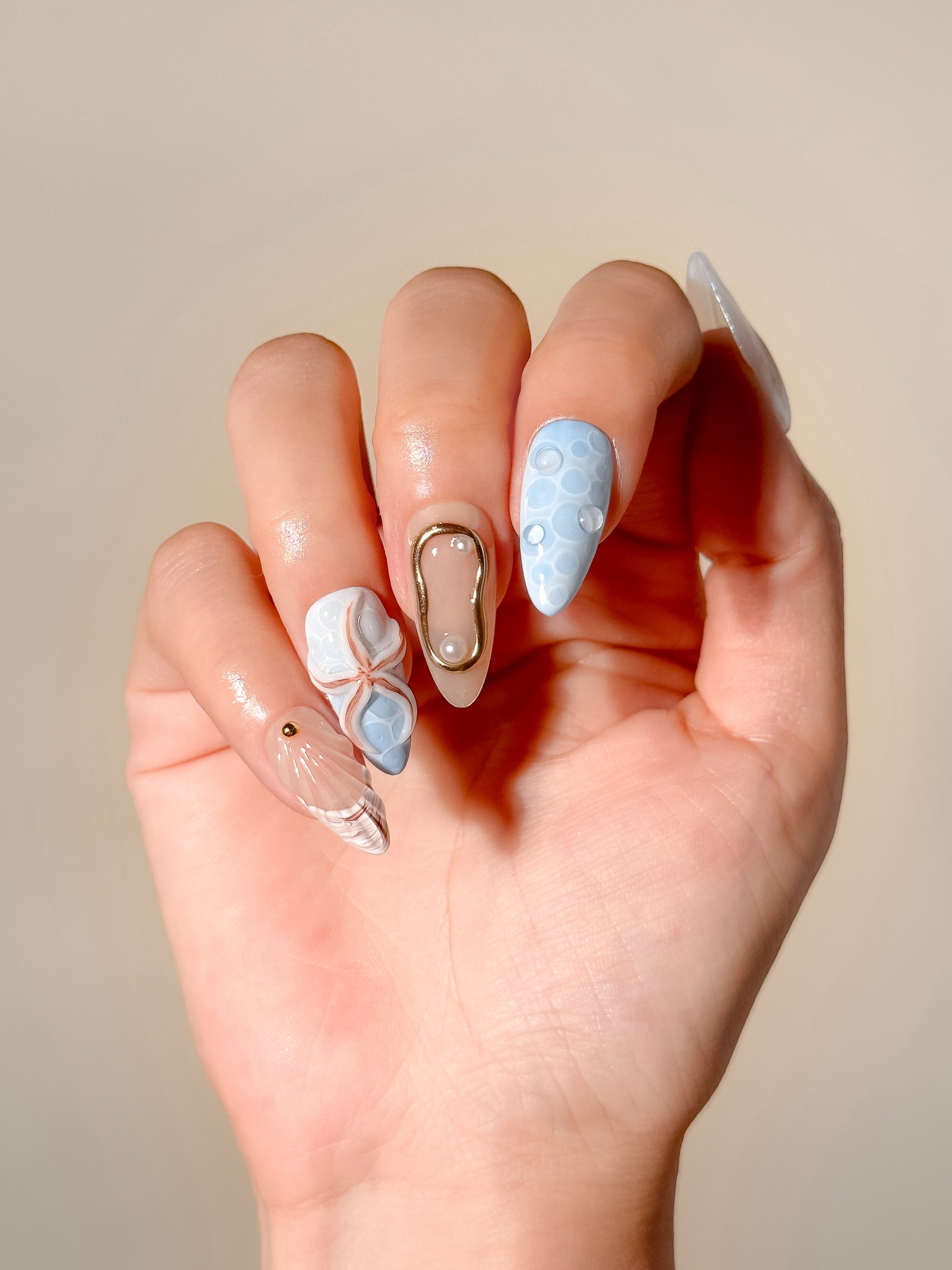 Laguna reusable handmade gel press-on nails with blue ocean texture, 3D shell designs, pearl embellishments and medium almond tips