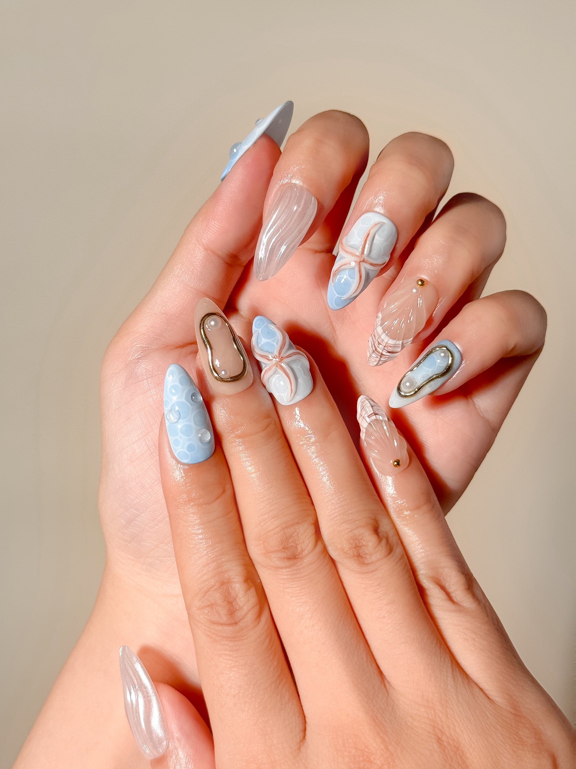 Laguna reusable handmade gel press-on nails with blue ocean texture, 3D shell designs, pearl embellishments and medium almond tips
