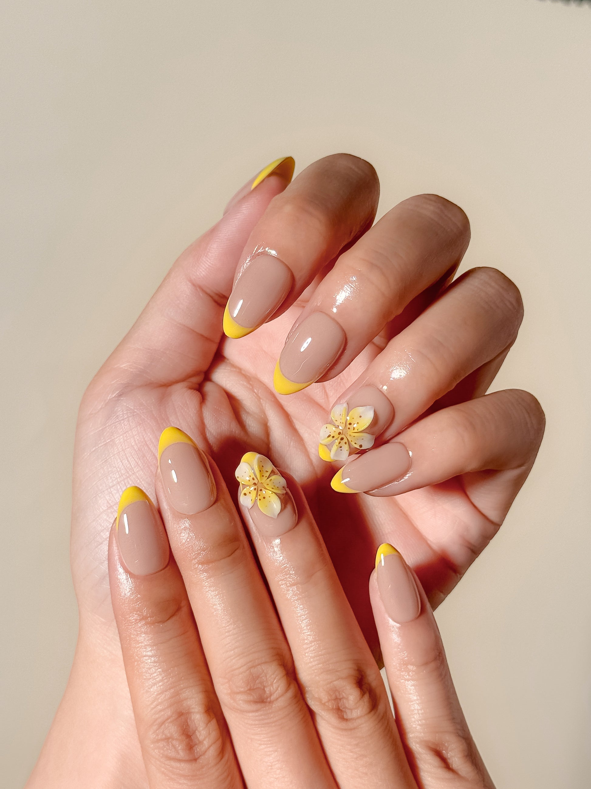Fresh lemon-yellow French tip press-on nails with a glossy finish, featuring a soft almond shape and a clean citrus-inspired design for a playful yet elevated look.