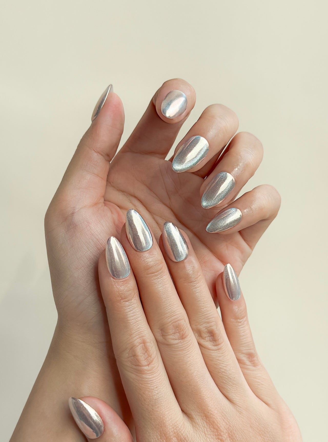 Silver chrome cat-eye press-on nails in a glossy short almond shape with reflective metallic detailing. Handmade reusable false nails inspired by liquid metal nails, futuristic chrome manicures and magnetic cat-eye nail trends.