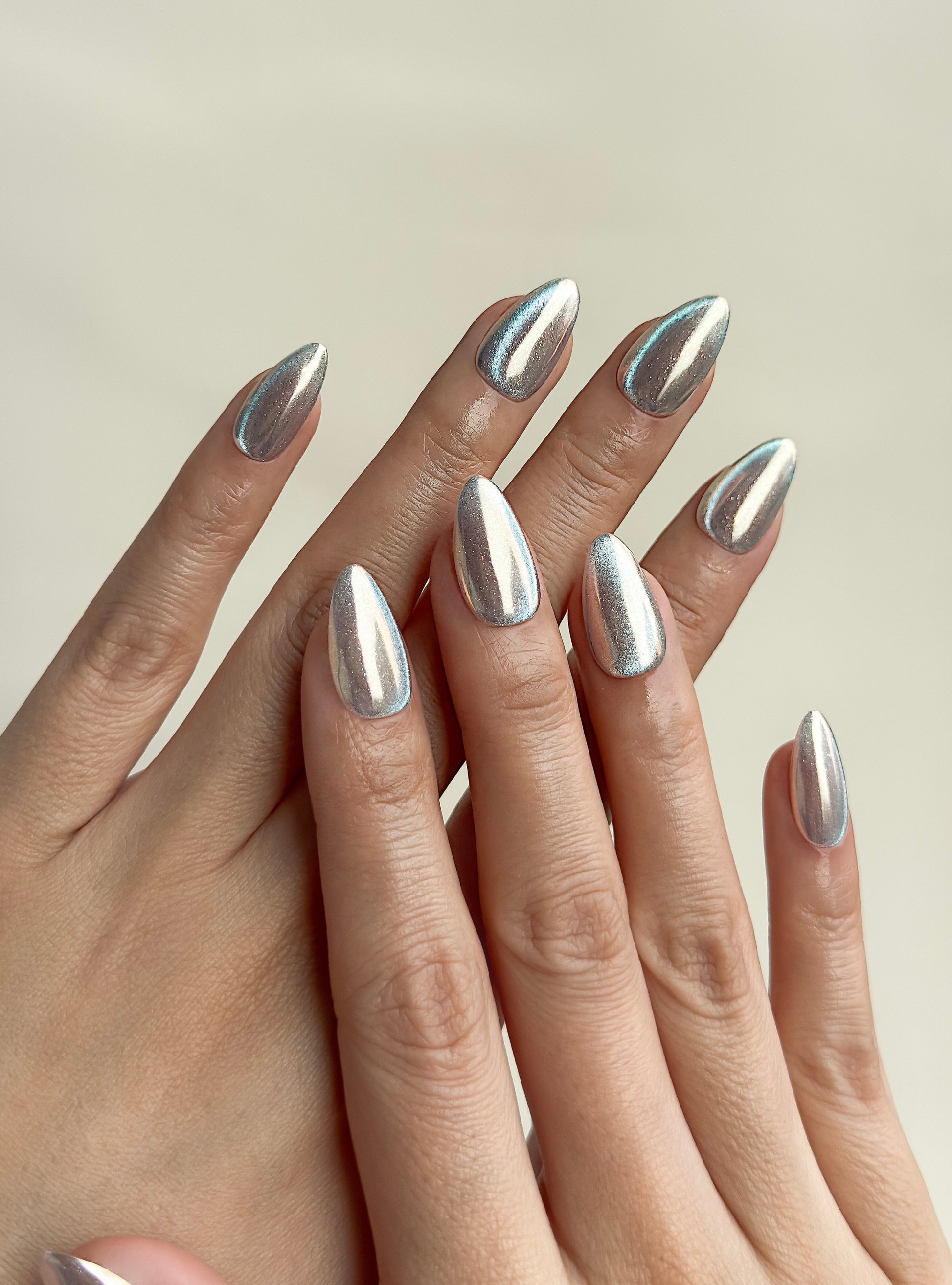 Silver chrome cat-eye press-on nails in a glossy short almond shape with reflective metallic detailing. Handmade reusable false nails inspired by liquid metal nails, futuristic chrome manicures and magnetic cat-eye nail trends.