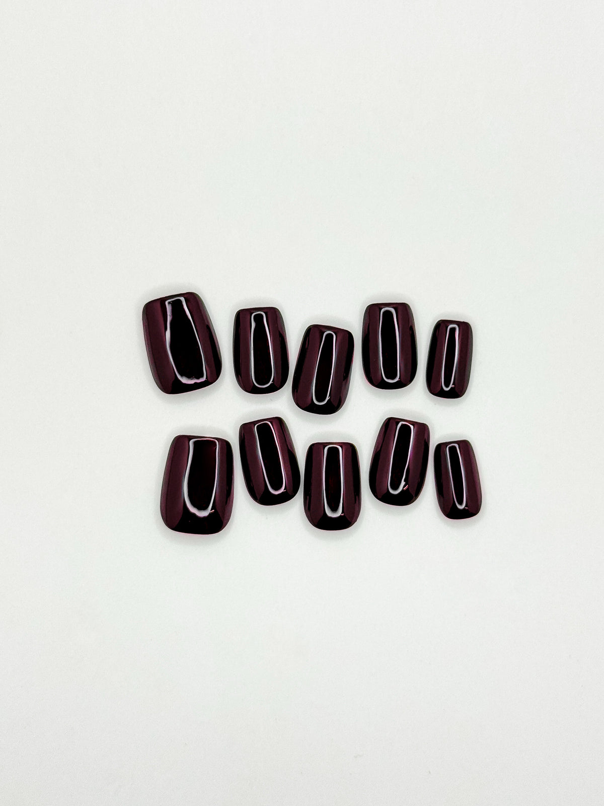OOO deep chestnut brown short square press-on nails arranged as a glossy reusable set on a white background.