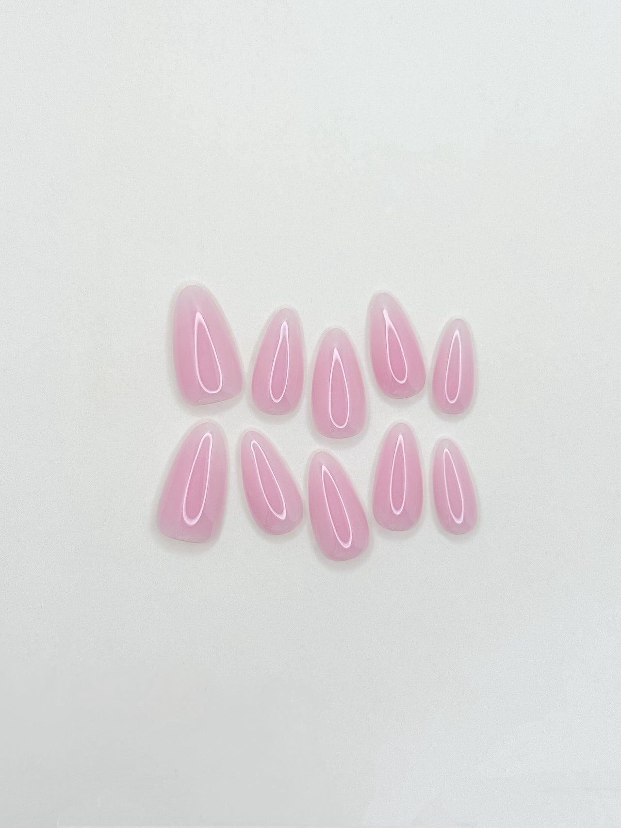 Glossy soft pink ombré press-on nails in a medium almond shape with a creamy gelato-inspired finish. Handmade reusable false nails featuring blended rosy nude tones for a clean, feminine and elevated everyday manicure.