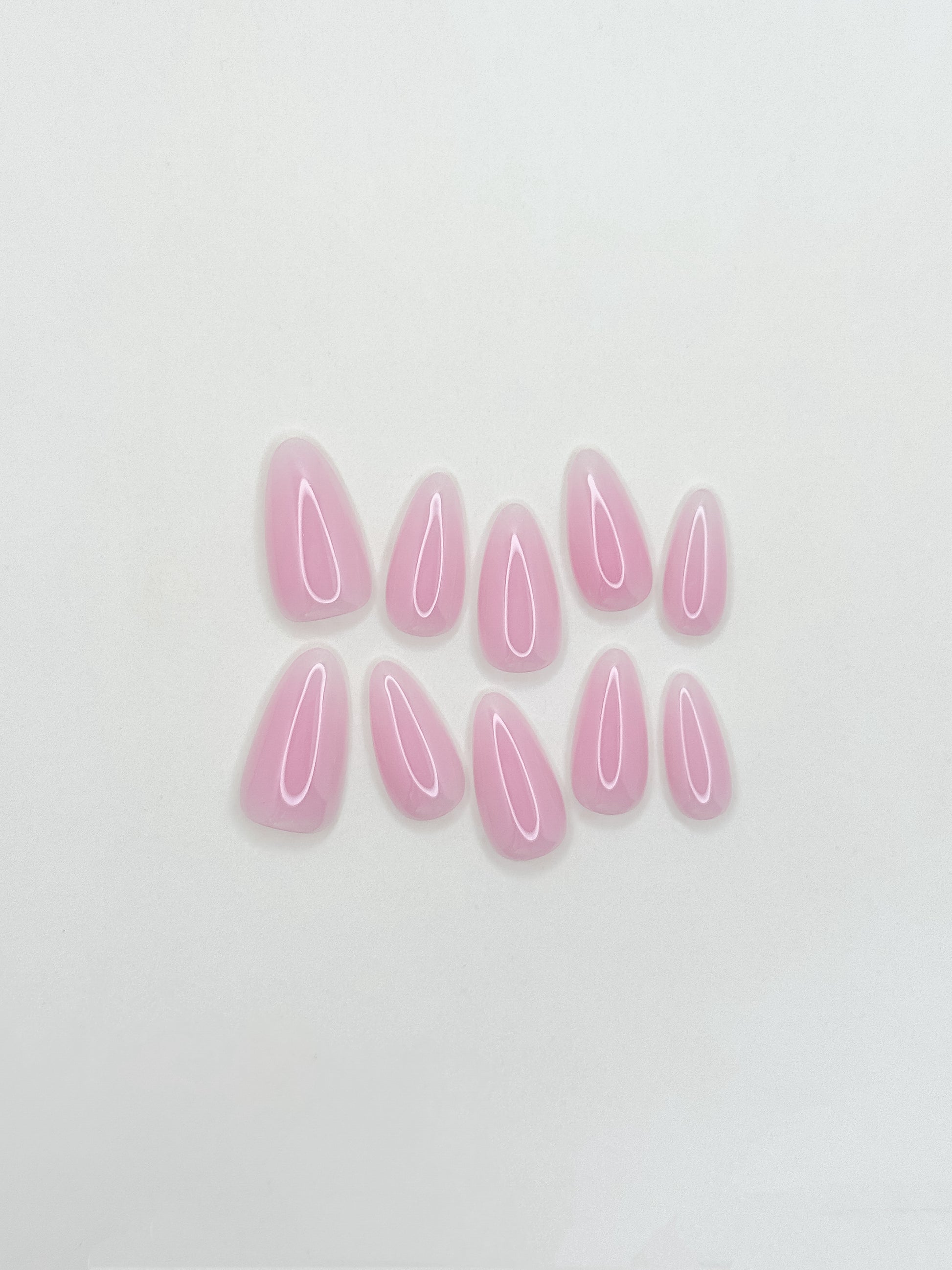 Glossy soft pink ombré press-on nails in a medium almond shape with a creamy gelato-inspired finish. Handmade reusable false nails featuring blended rosy nude tones for a clean, feminine and elevated everyday manicure.