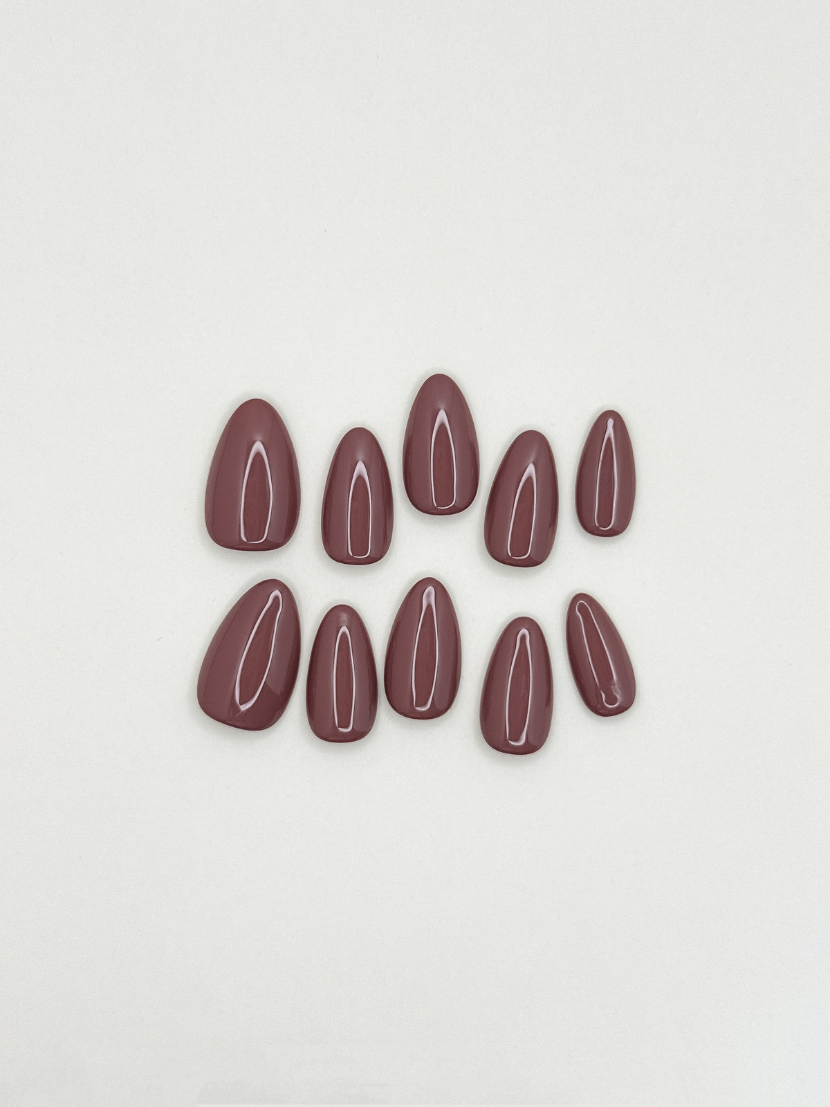 Velvet Blush mauve-taupe short almond press-on nails laid flat, showing a glossy solid neutral finish.
