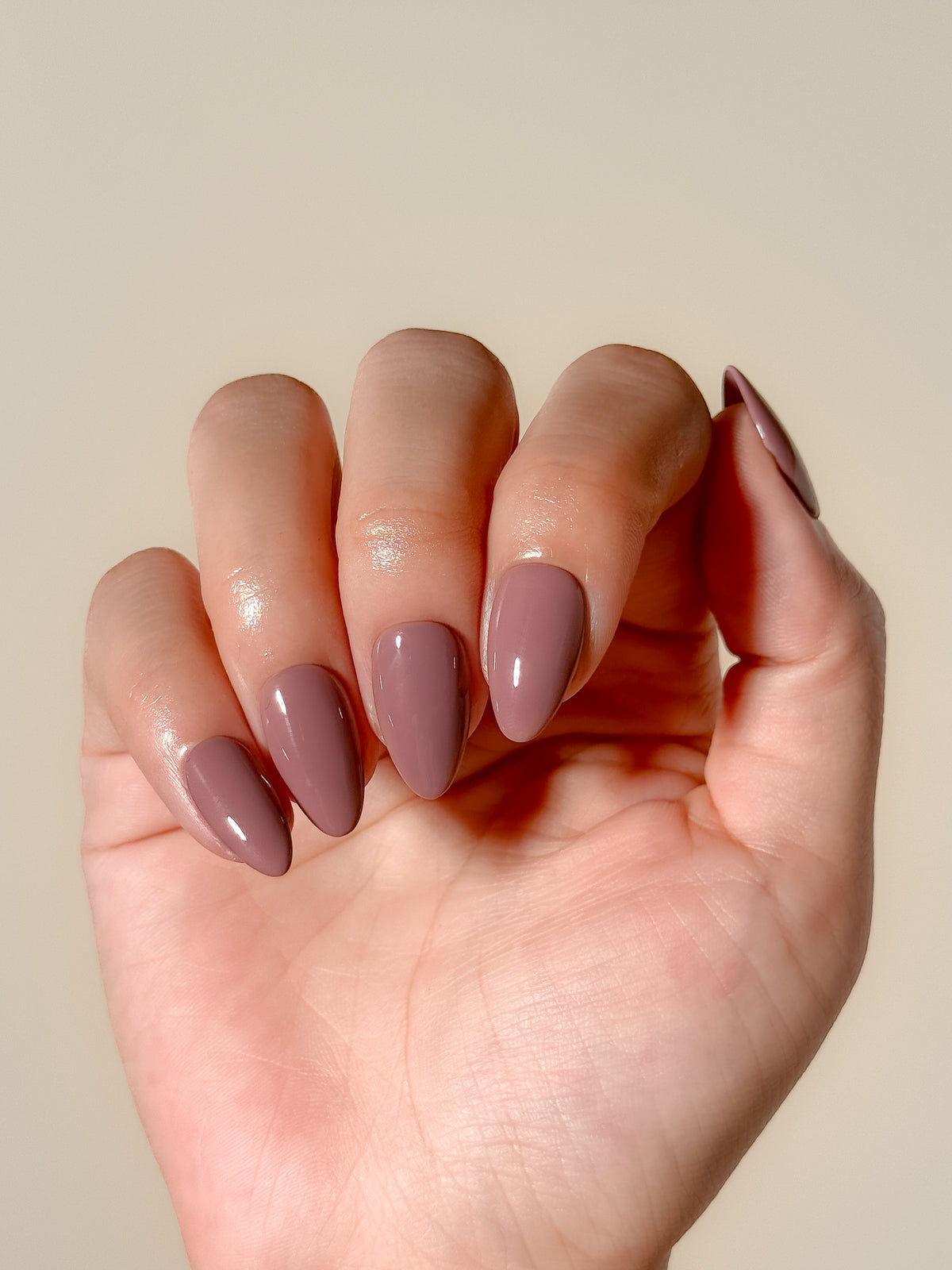 Velvet Blush mauve-taupe short almond press-on nails laid flat, showing a glossy solid neutral finish.