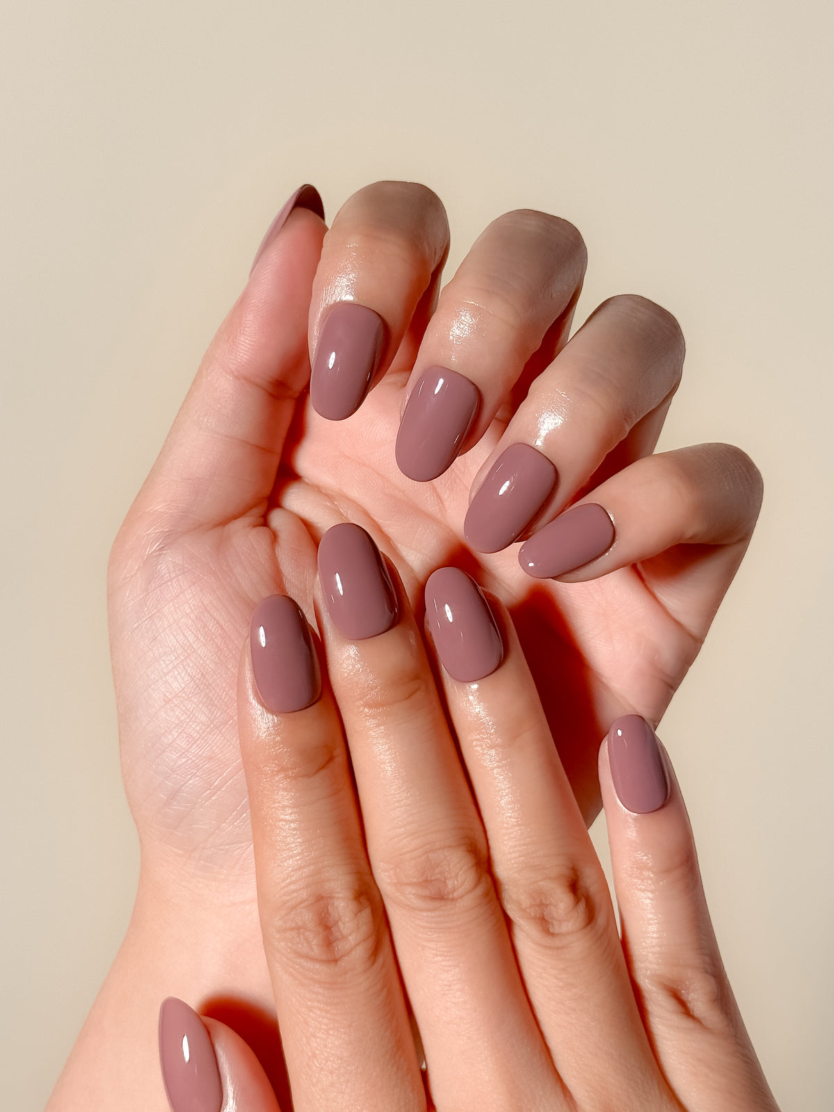 Velvet Blush mauve-taupe short oval press-on nails worn on both hands, showing a rounded natural shape.