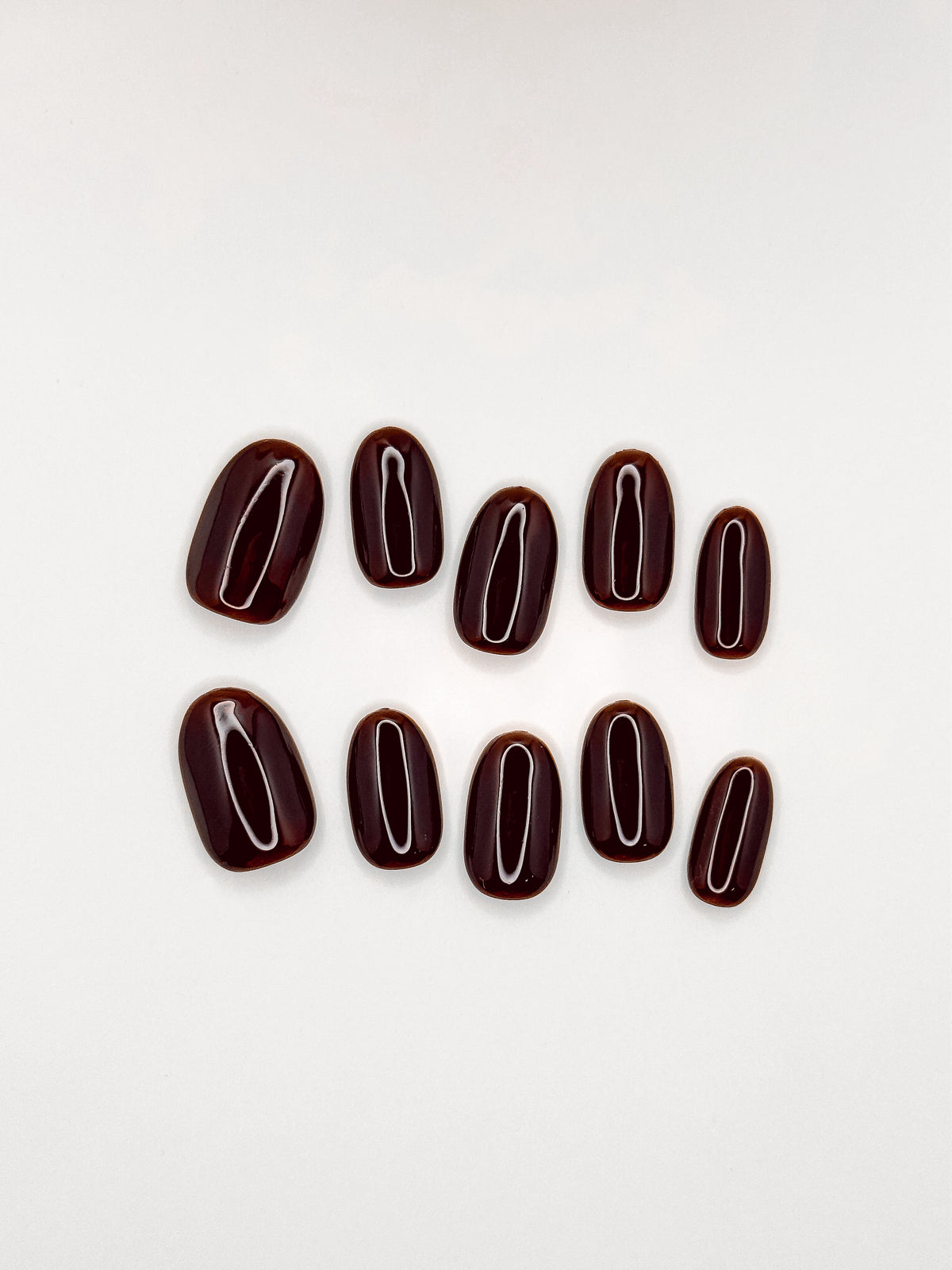 Coffee Break deep espresso brown short oval press-on nails arranged as a glossy reusable set on a white background.