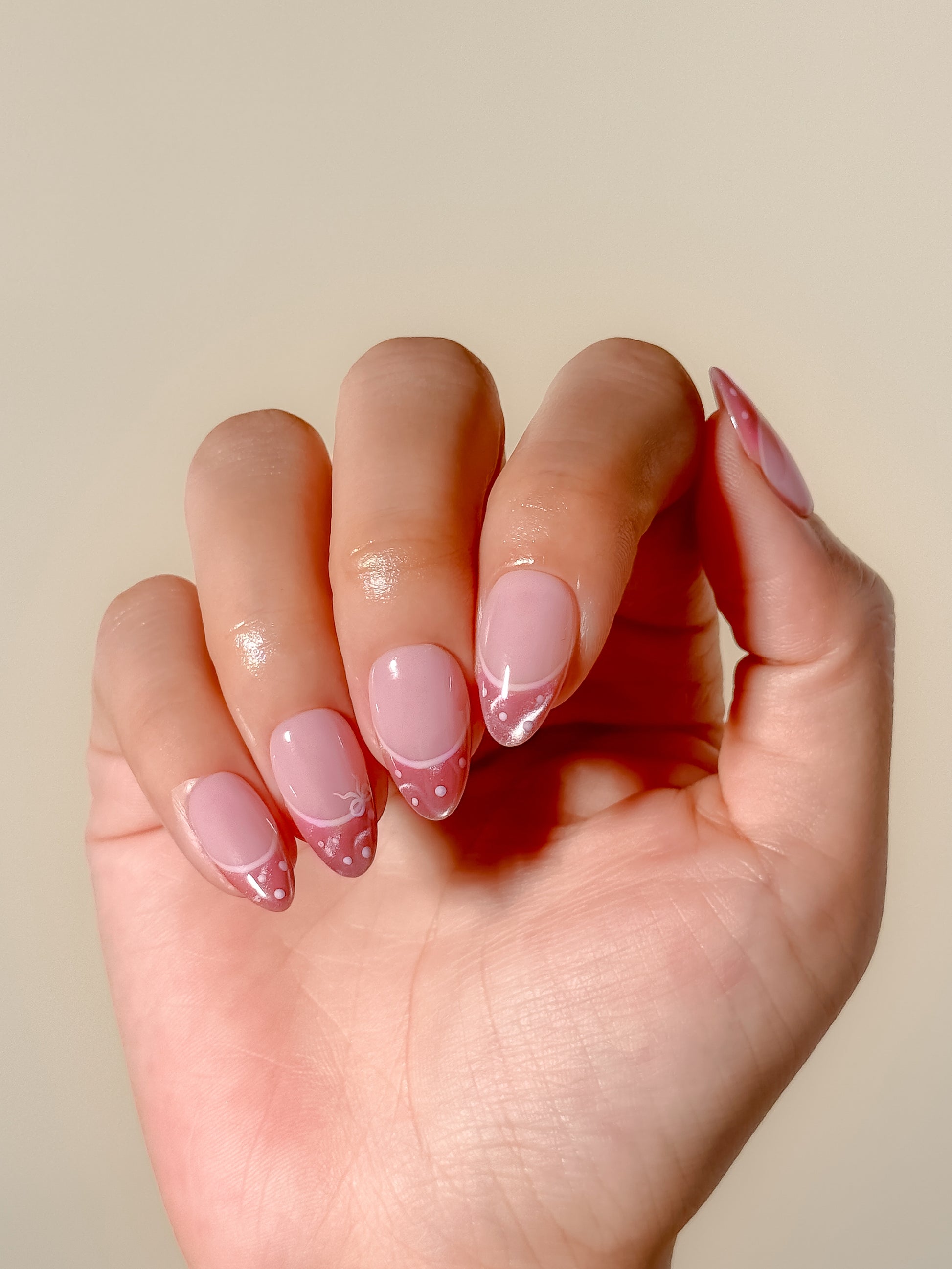 Doe Eyes pink cat-eye skinny French tip press-on nails worn on one hand