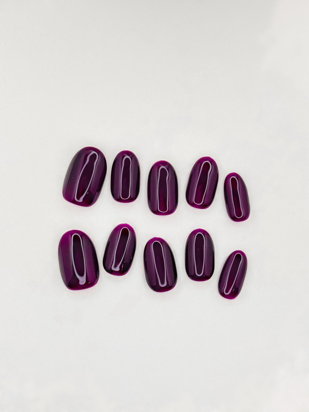Office Crush deep aubergine purple short oval press-on nails arranged as a glossy reusable set on a white background.